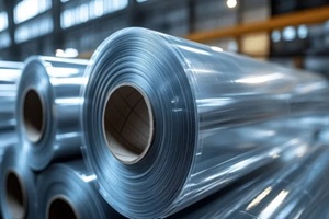 Industrial plastic film rolls stacked horizontally, showcasing their reflective surfaces, smooth cylindrical bodies, and clean industrial feel